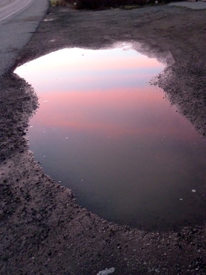 Red stripes reflected in puddle
